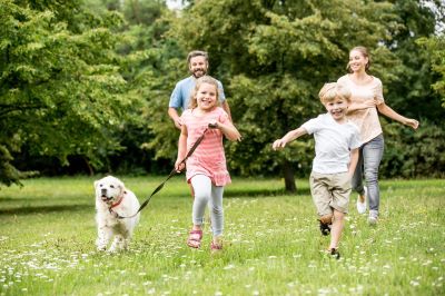 Family, happily running with dog